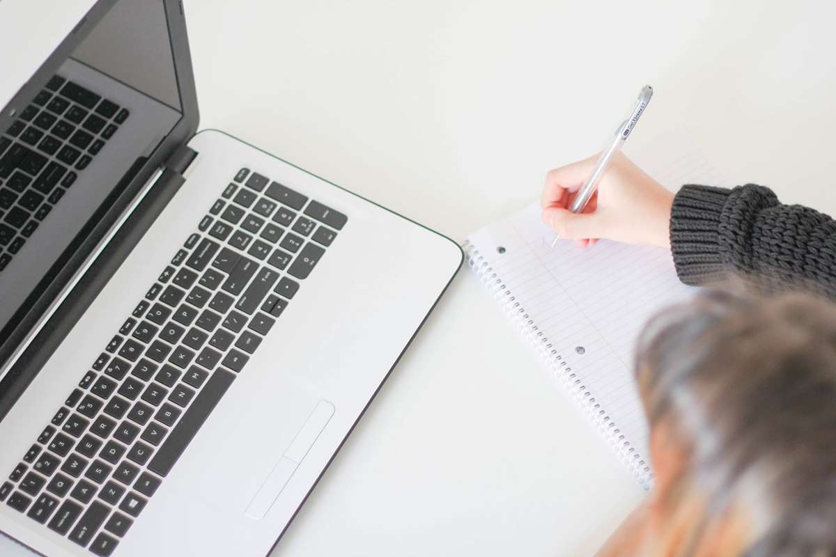 Laptop with woman making notes