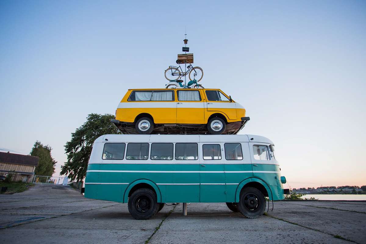 Bicycle on top of van on top of bus